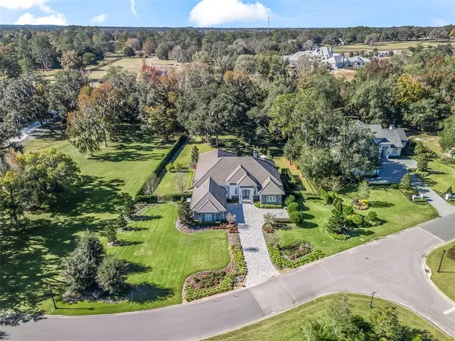 an aerial view of residential houses with outdoor space and trees