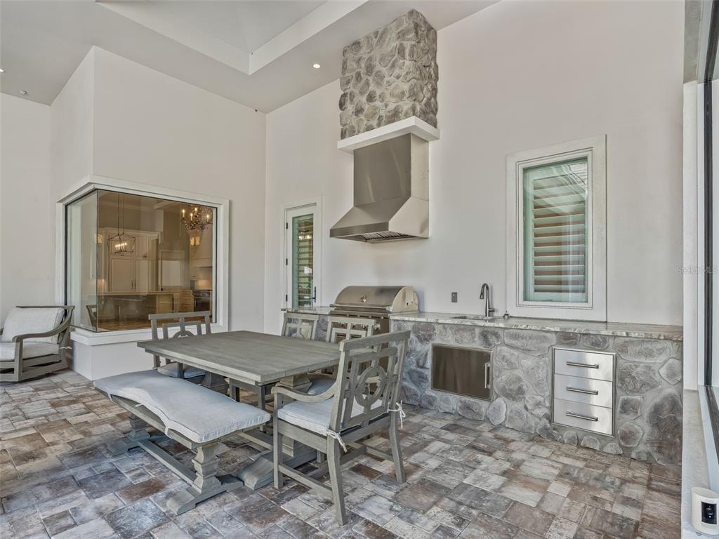 8746 Northwest 31st Lane Road Ocala, FL 34482 - Photo 70 of 89 a outdoor kitchen with a stove a sink and chairs