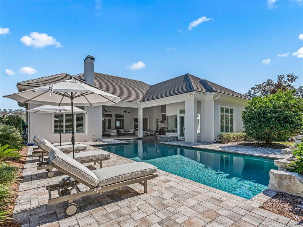 8746 Northwest 31st Lane Road Ocala, FL 34482 - Photo 77 of 89 a patio with a table and chairs under an umbrella