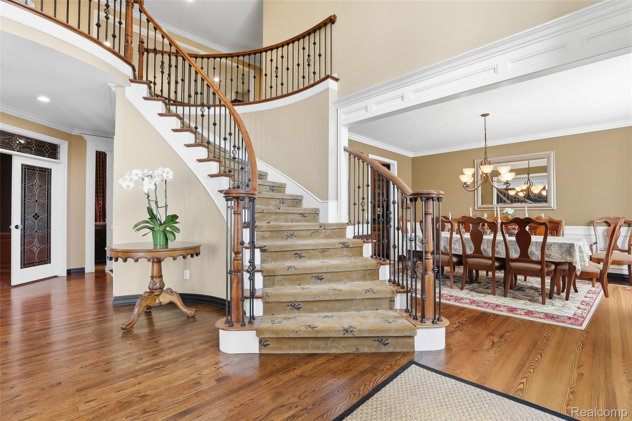 668 Springview Drive Rochester, MI 48307 - Photo 10 of 90 Stairs with crown molding, hanging lights, wood finished floors, and a high ceiling