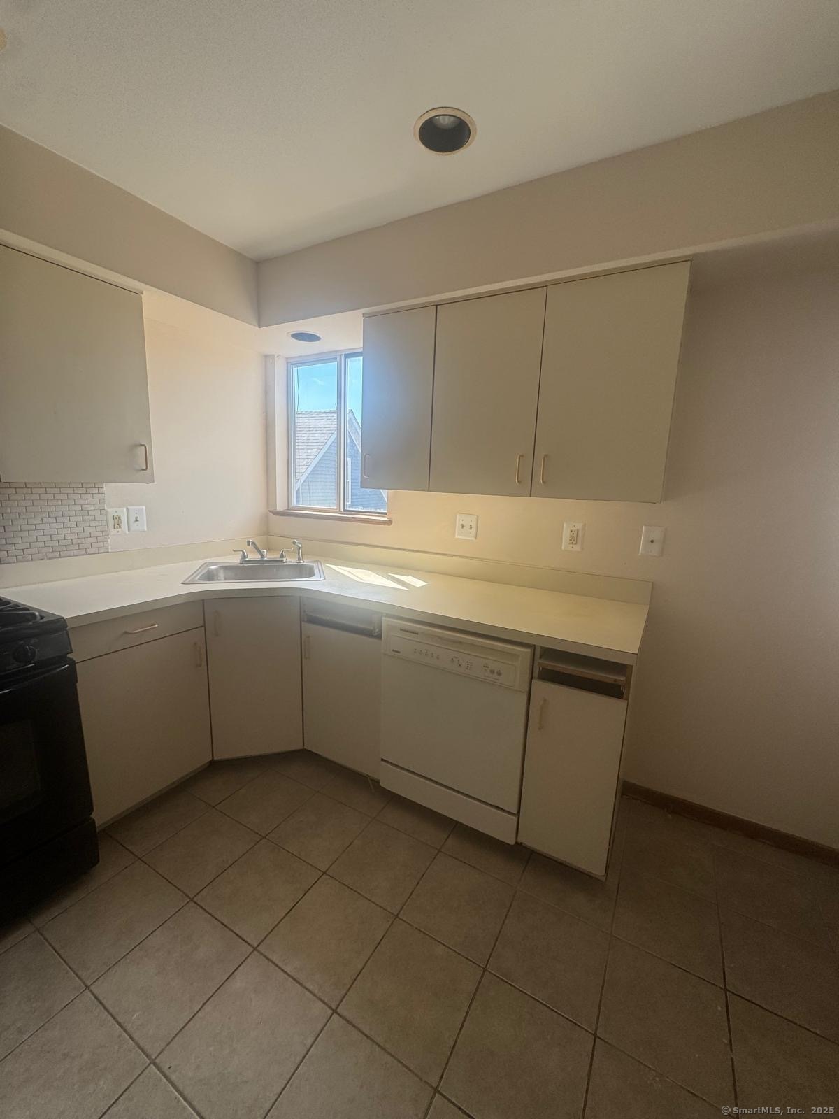 204 Wheeler Avenue, Unit 6 Bridgeport, CT 06606 - Photo 2 of 15 a kitchen with a sink cabinets and window