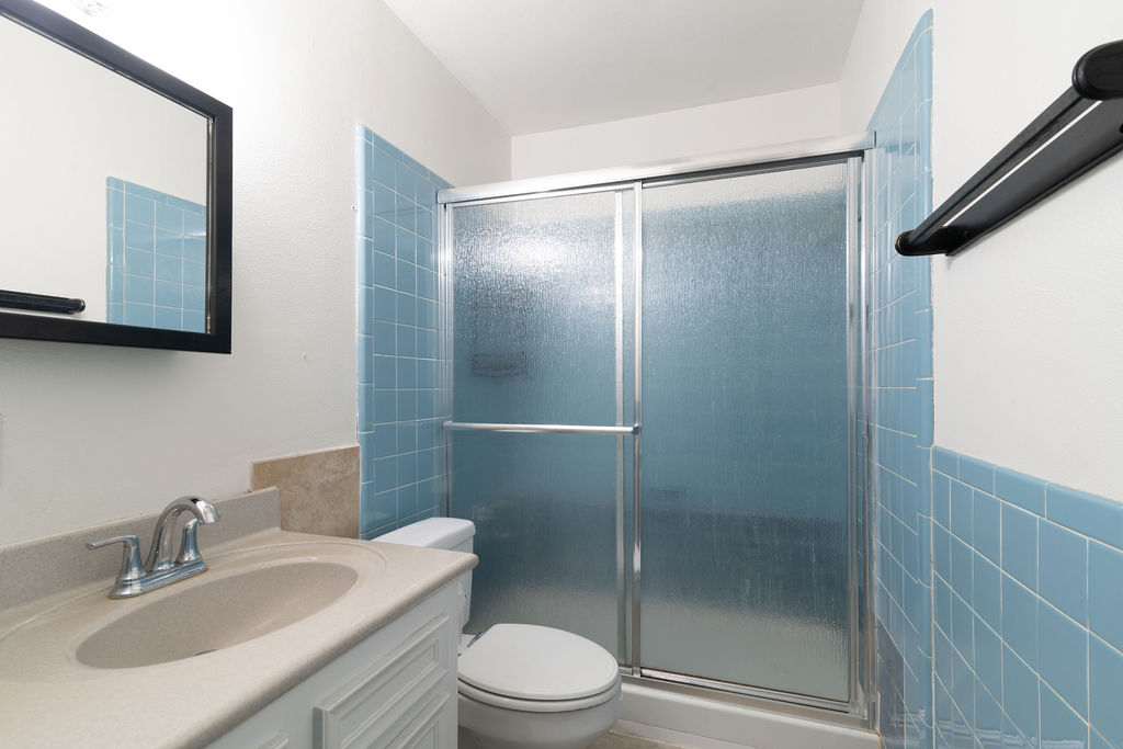 1106 Saucedo Street Austin, TX 78721 - Photo 18 of 34 Bathroom with a shower stall, vanity, and tile walls