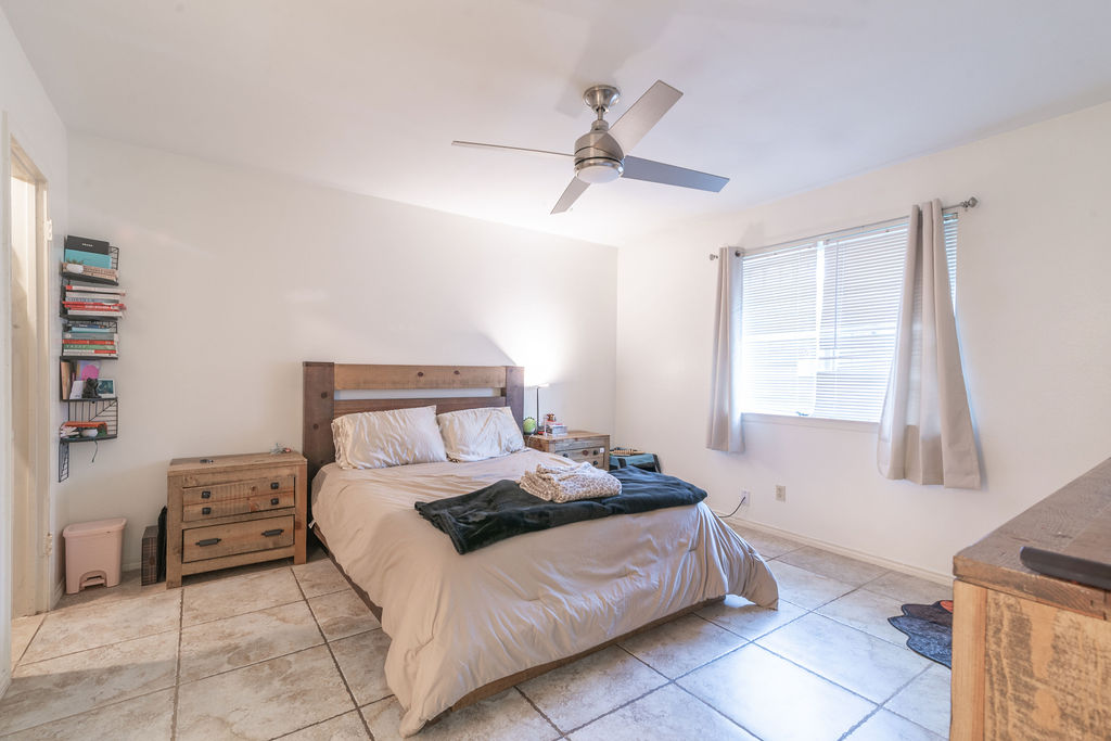 1106 Saucedo Street Austin, TX 78721 - Photo 19 of 34 Bedroom featuring light tile patterned floors and a ceiling fan