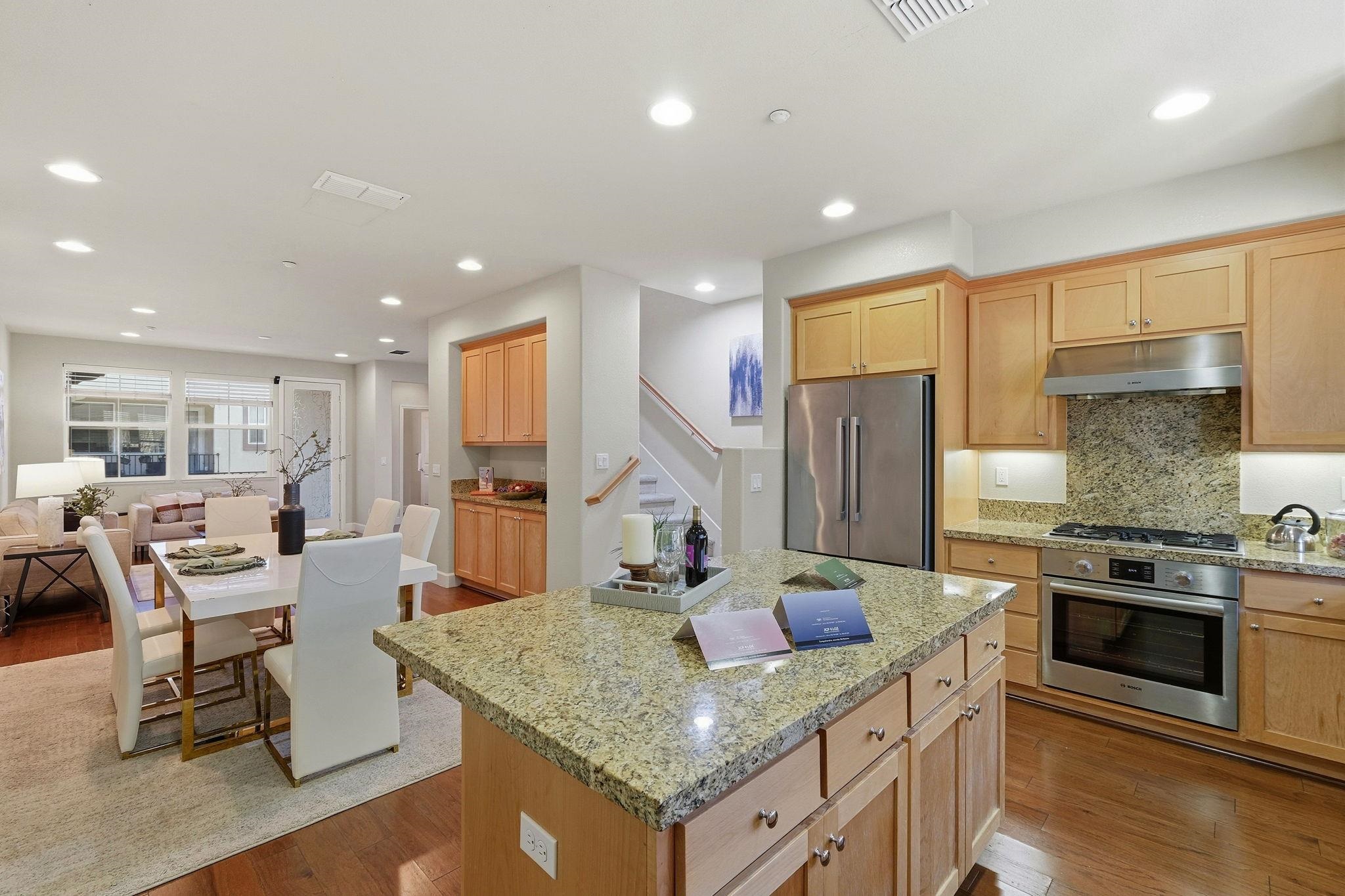 2863 Finca Terrace Fremont, CA 94539 - Photo 10 of 37 a kitchen with stainless steel appliances granite countertop a stove a sink a refrigerator and chairs