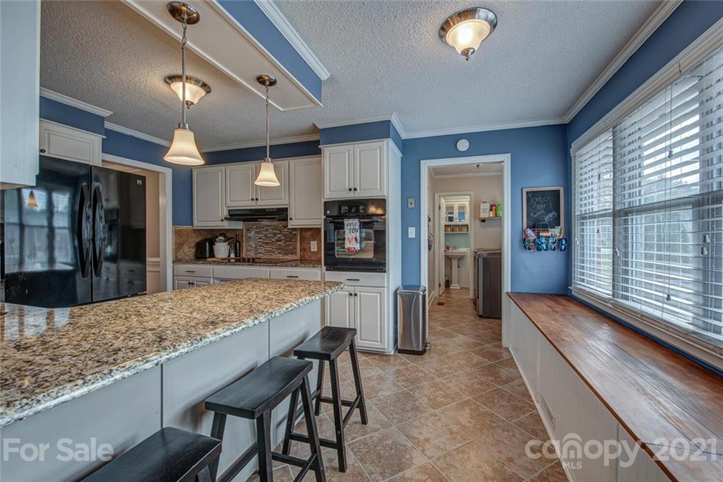 2103 Heavner Road Lincolnton, NC 28092 - Photo 12 of 25 a kitchen with stainless steel appliances granite countertop table chairs sink and cabinets