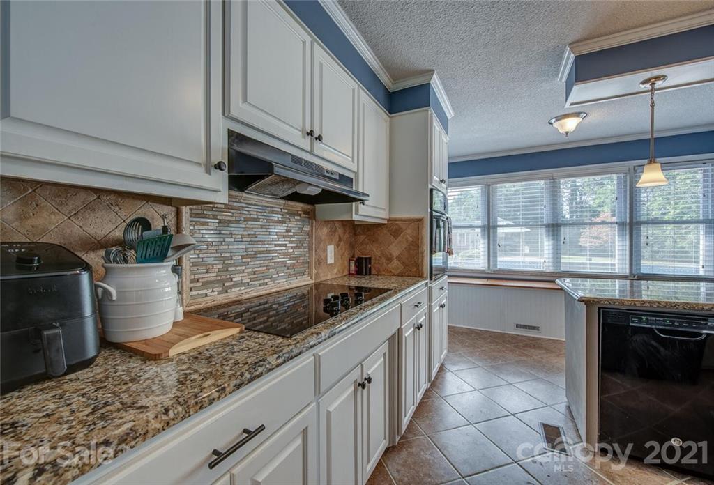 2103 Heavner Road Lincolnton, NC 28092 - Photo 14 of 25 a kitchen with stainless steel appliances granite countertop a sink a stove and a wooden cabinets