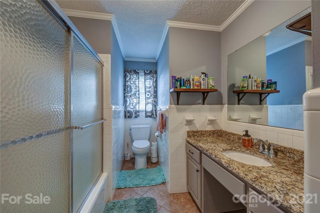 2103 Heavner Road Lincolnton, NC 28092 - Photo 22 of 25 a bathroom with a granite countertop sink a toilet and a shower