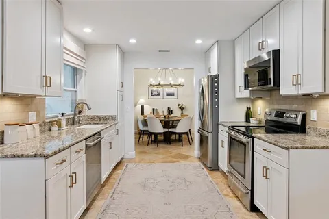 a kitchen with stainless steel appliances granite countertop a sink and cabinets