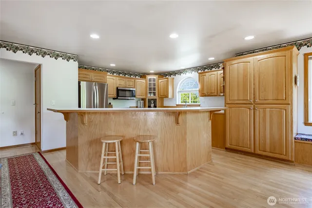 a kitchen with kitchen island granite countertop wooden floors and white stainless steel appliances