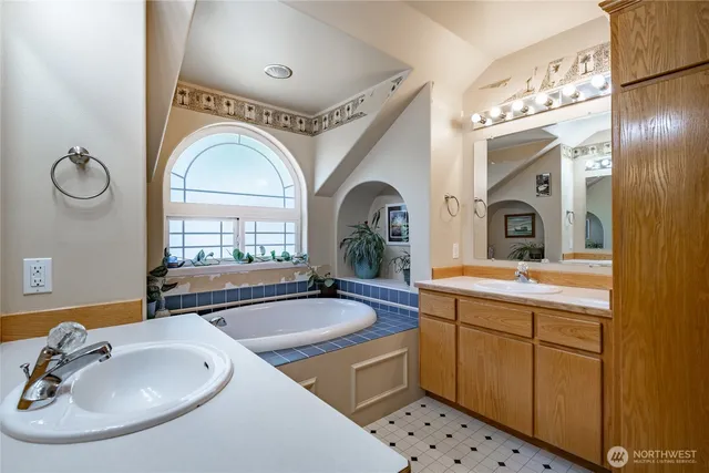 a spacious bathroom with a sink mirror and tub
