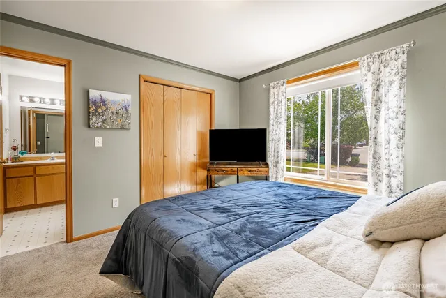 a bedroom with a large bed and a flat screen tv