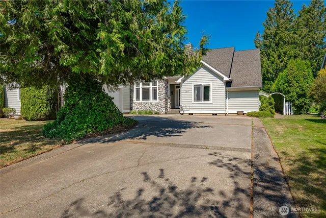 a front view of a house with a yard and trees