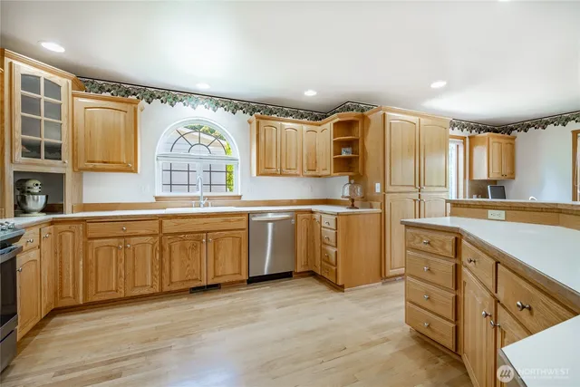 a kitchen with granite countertop a sink window and stainless steel appliances