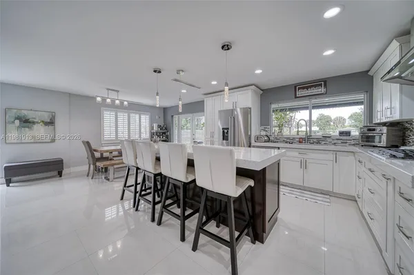 a kitchen with white cabinets and chairs