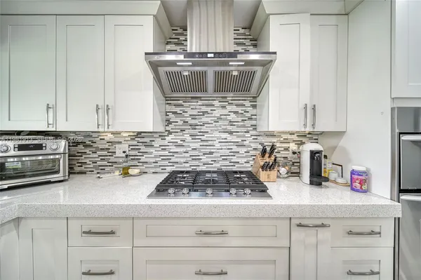 a large white kitchen with a large window