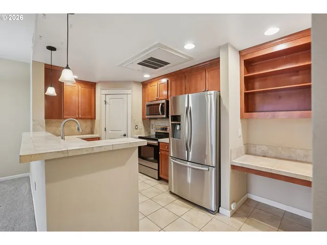 a kitchen with kitchen island a counter top space stainless steel appliances and cabinets