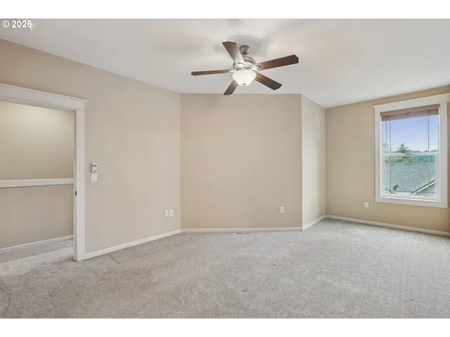 a view of an empty room with window and closet area