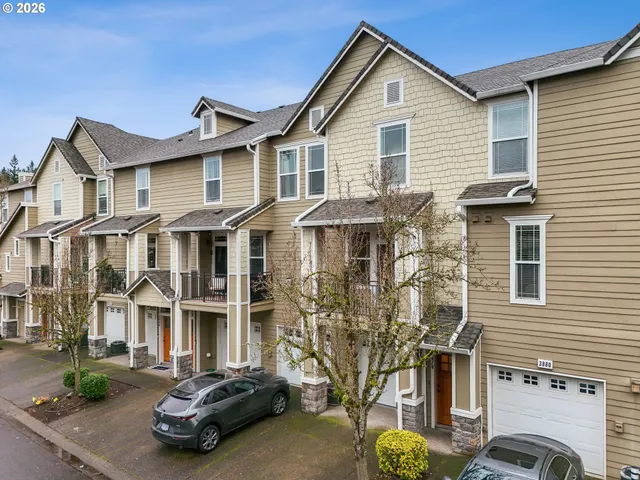 a view of a white house with large windows next to a road