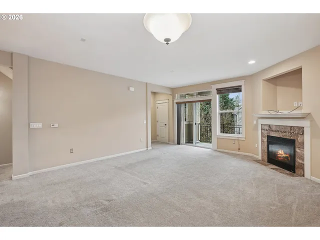 a view of an empty room with a fireplace and a window