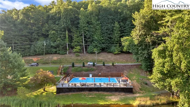 a view of a swimming pool with lawn chairs under an umbrella