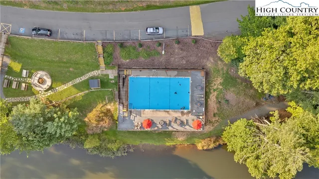 a aerial view of a house with swimming pool and large trees