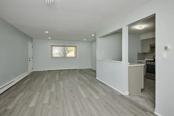 a view of an empty room with wooden floor