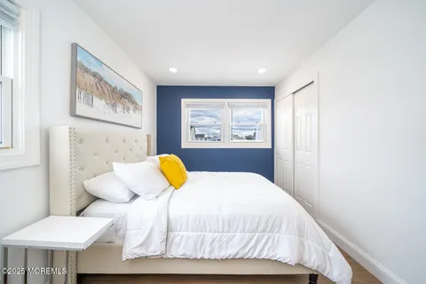 a bedroom with a bed a couch and paintings on the wall