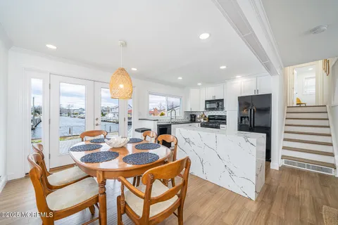 a dining room with furniture a large window and stainless steel appliances