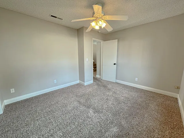 an empty room with a chandelier fan and a chandelier fan