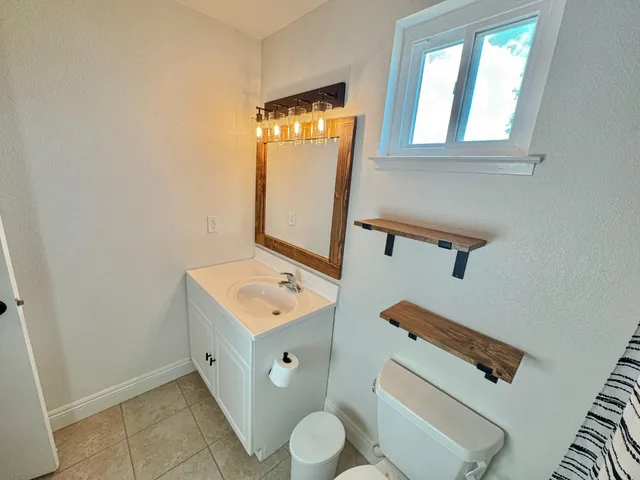 a bathroom with a toilet sink and mirror