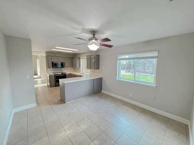 a view of kitchen with stainless steel appliances cabinets and window
