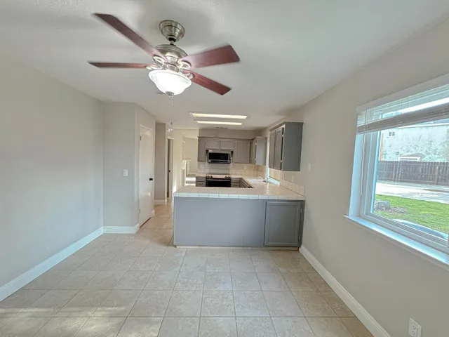 a large kitchen with a window and stainless steel appliances