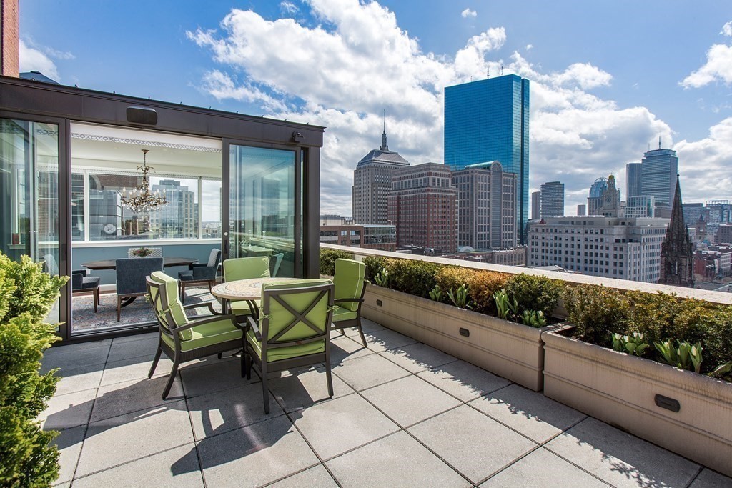 2 Commonwealth Avenue, Unit PH 3/4 Boston, MA 02215 - Photo 9 of 29 a roof deck with table and chairs and potted plants