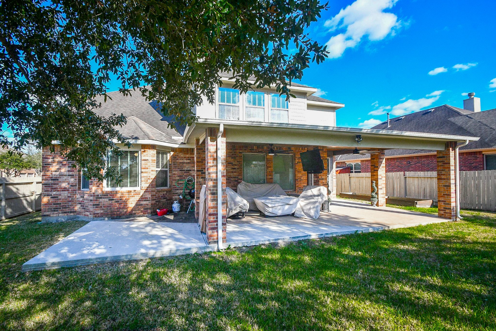 4331 Estes Ridge Lane Katy, TX 77493 - Photo 41 of 42 a view of a backyard with table and chairs and a large tree