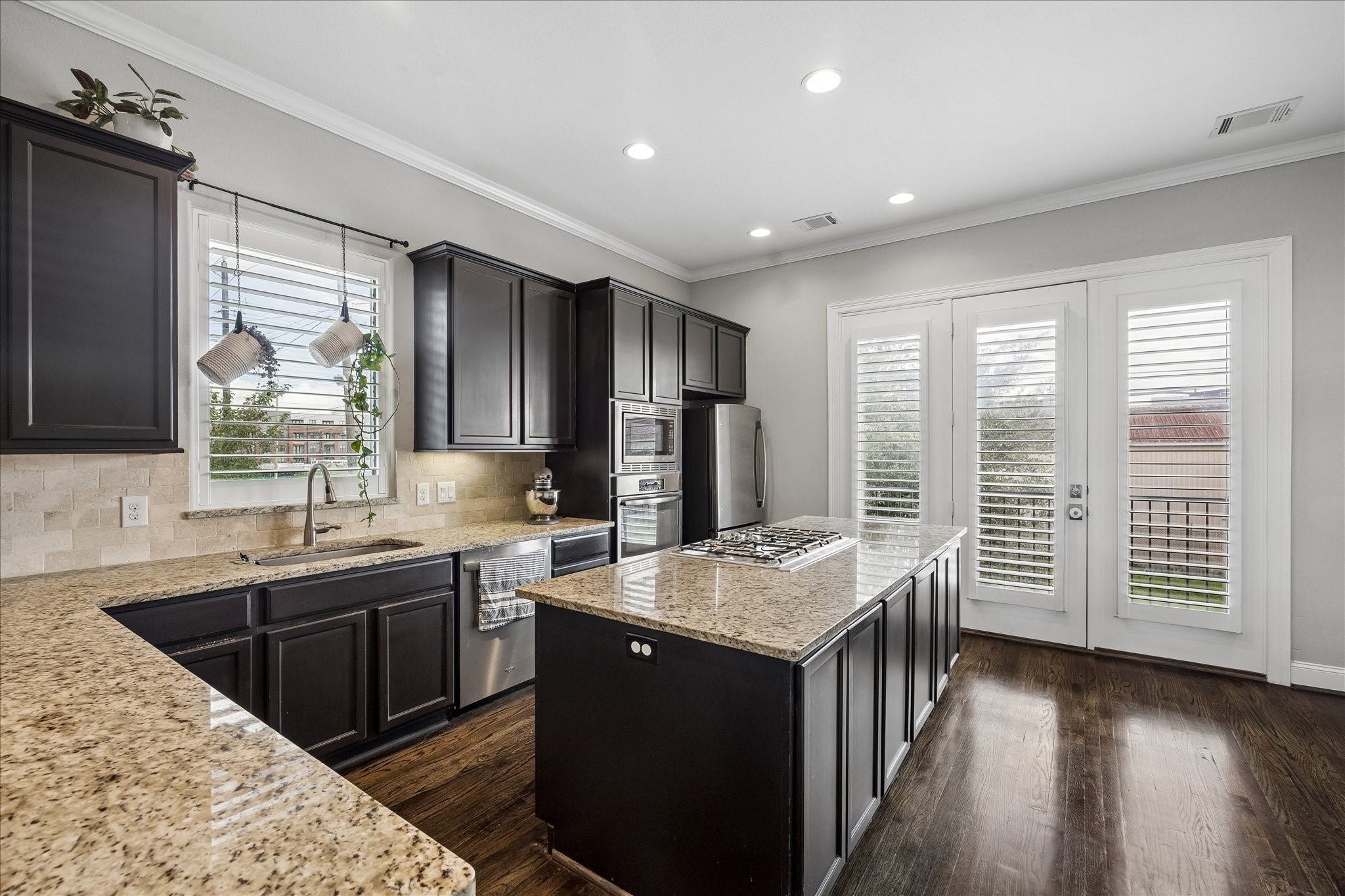 1915 Spring Street Houston, TX 77007 - Photo 7 of 40 The kitchen has granite countertops and tile backsplash. The glass windows and door are to the small front balcony