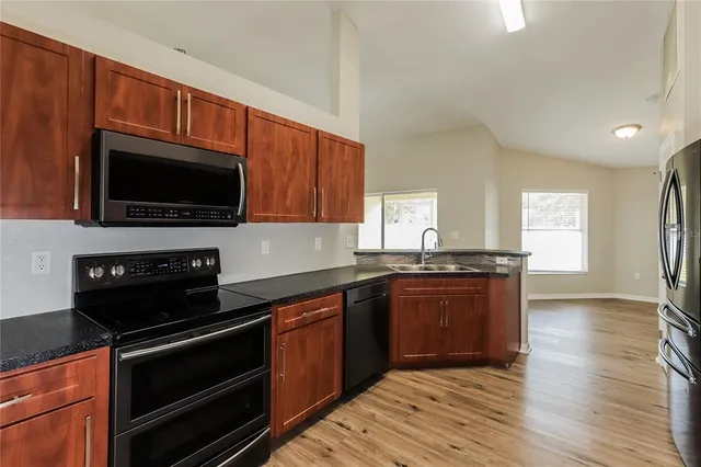 a kitchen with stainless steel appliances a stove microwave and sink
