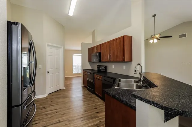 a kitchen with stainless steel appliances granite countertop a sink a stove and a refrigerator