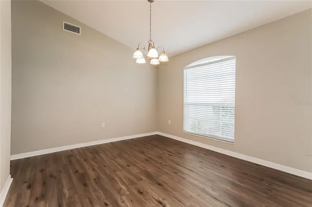 a view of wooden floor and a chandelier in a room