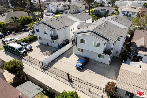 an aerial view of residential houses with outdoor space and parking