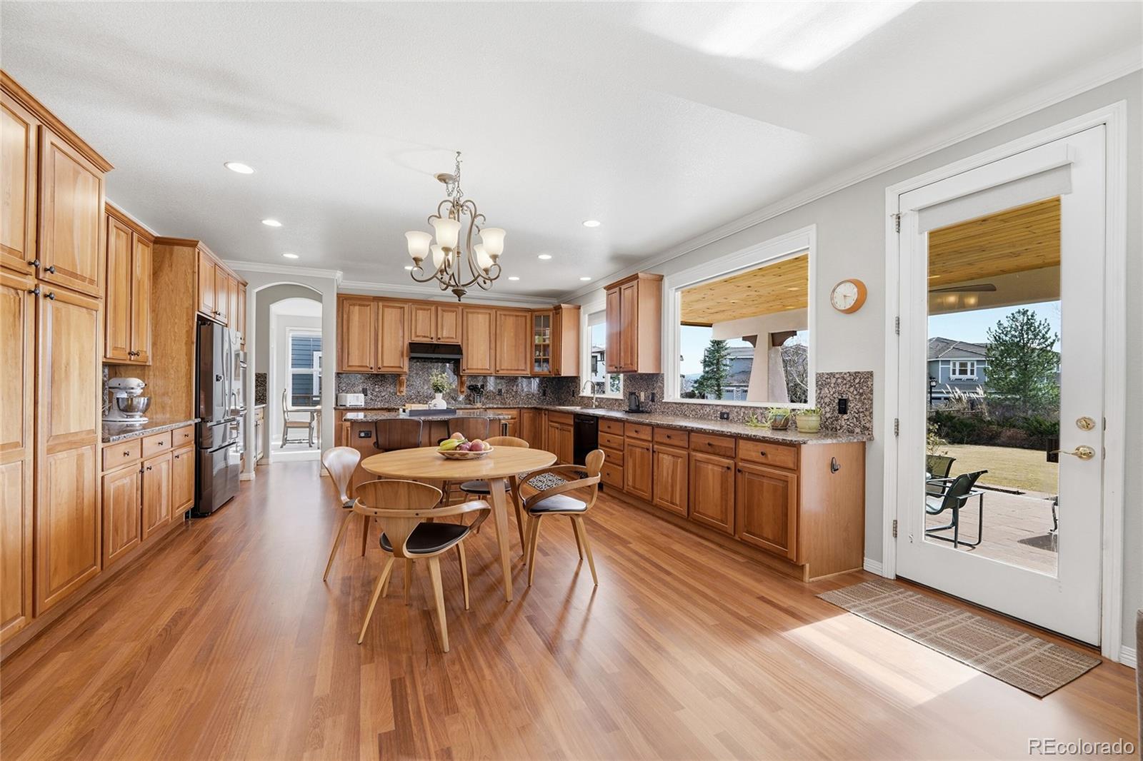 8967 Hunters Way Highlands Ranch, CO 80129 - Photo 21 of 50 a very nice looking open dining room with kitchen island furniture a large window and kitchen view