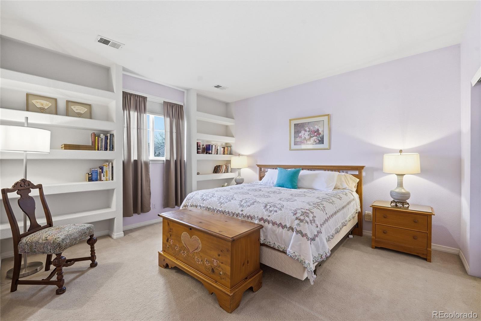 8967 Hunters Way Highlands Ranch, CO 80129 - Photo 32 of 50 a spacious bedroom with a bed a table and a couch