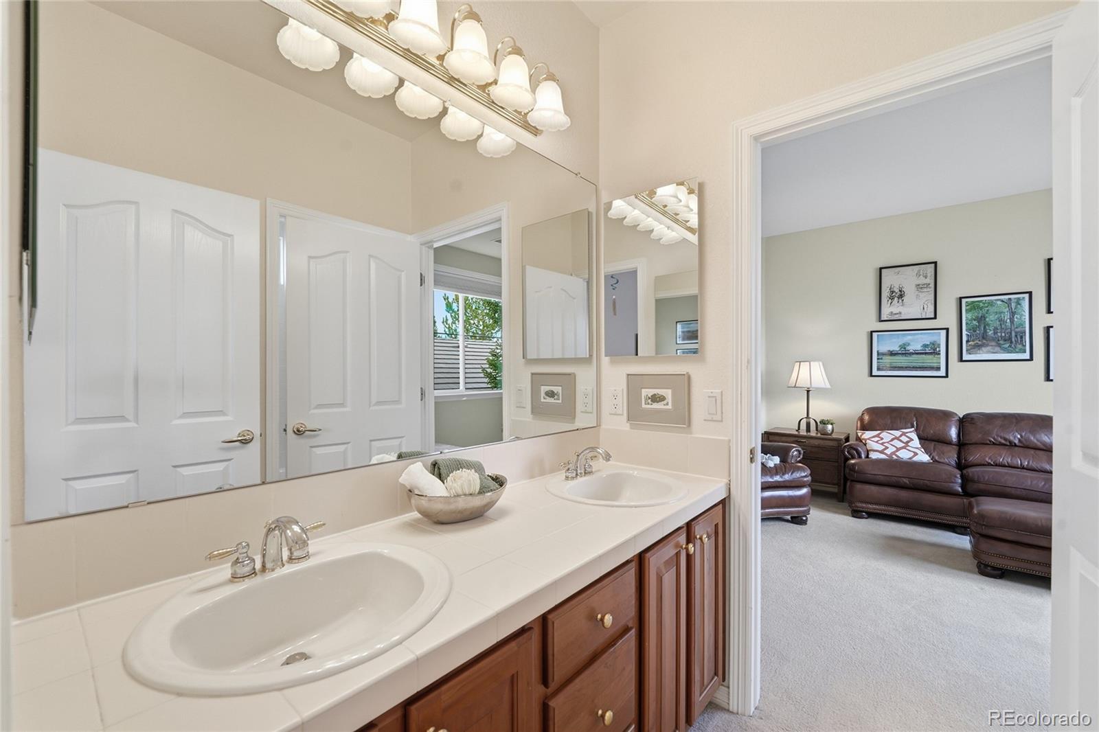 8967 Hunters Way Highlands Ranch, CO 80129 - Photo 35 of 50 a en suite bathroom with a granite countertop sink a toilet a mirror and shower