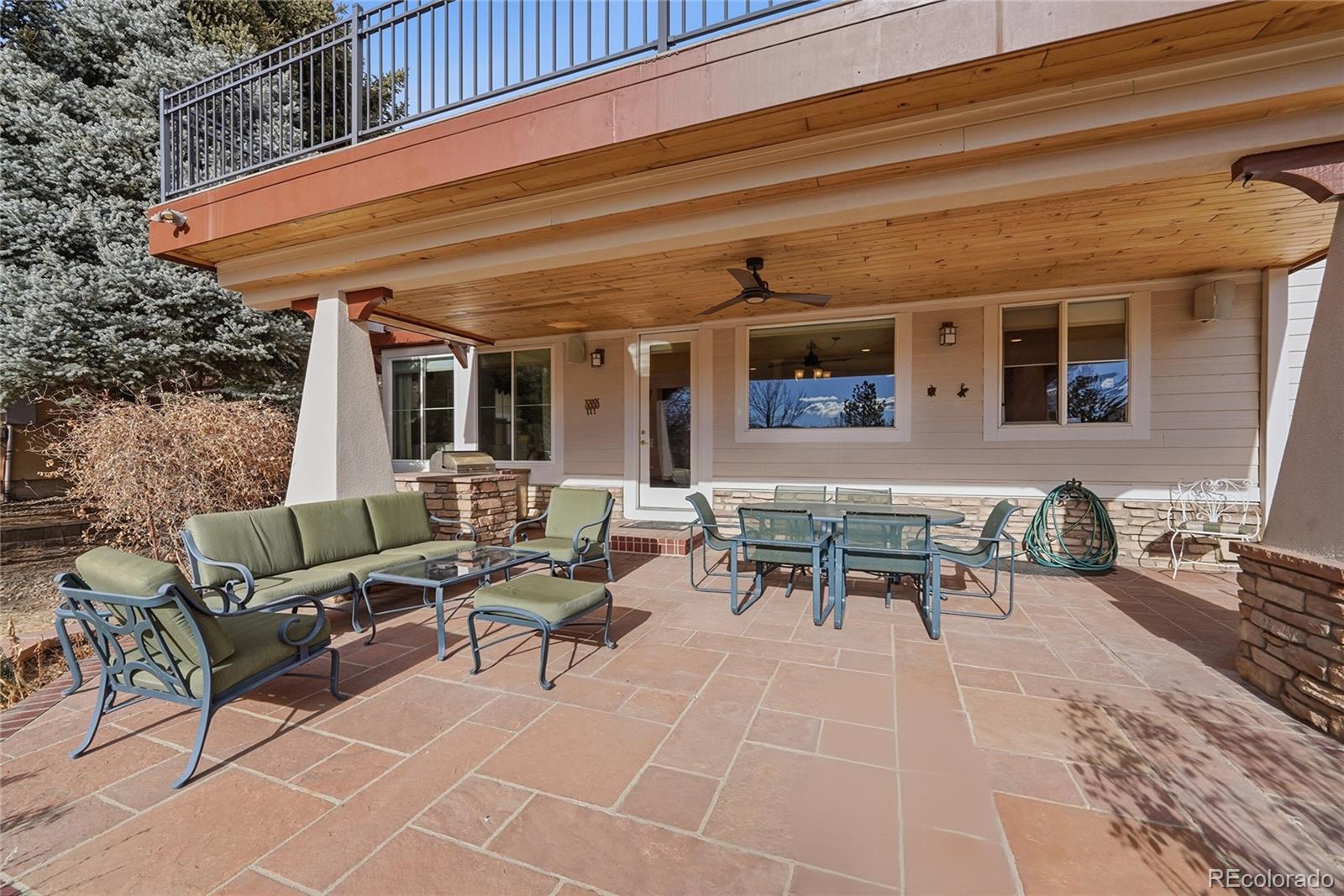 8967 Hunters Way Highlands Ranch, CO 80129 - Photo 42 of 50 a view of a patio with table and chairs with wooden floor and fence