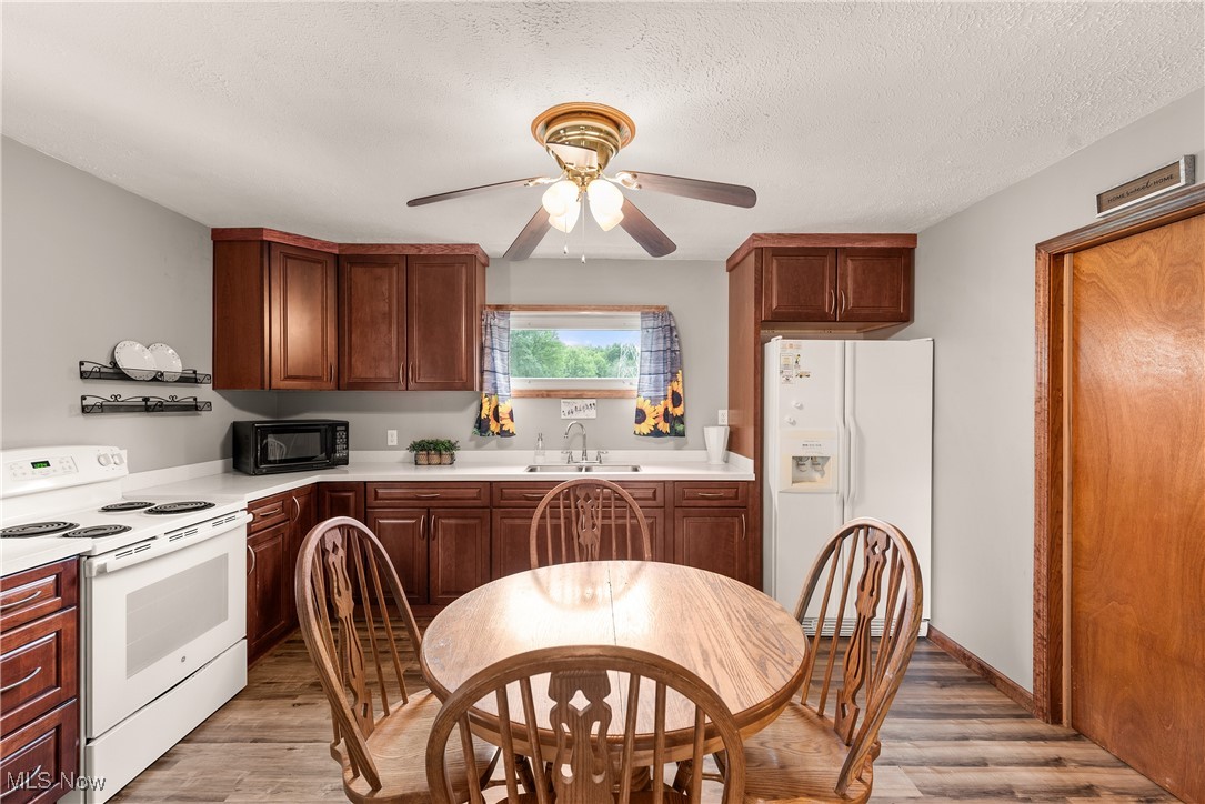 14808 Wheeler Road Lagrange, OH 44050 - Photo 15 of 50 Kitchen featuring white appliances, light wood-style floors, light countertops, a textured ceiling, and a ceiling fan