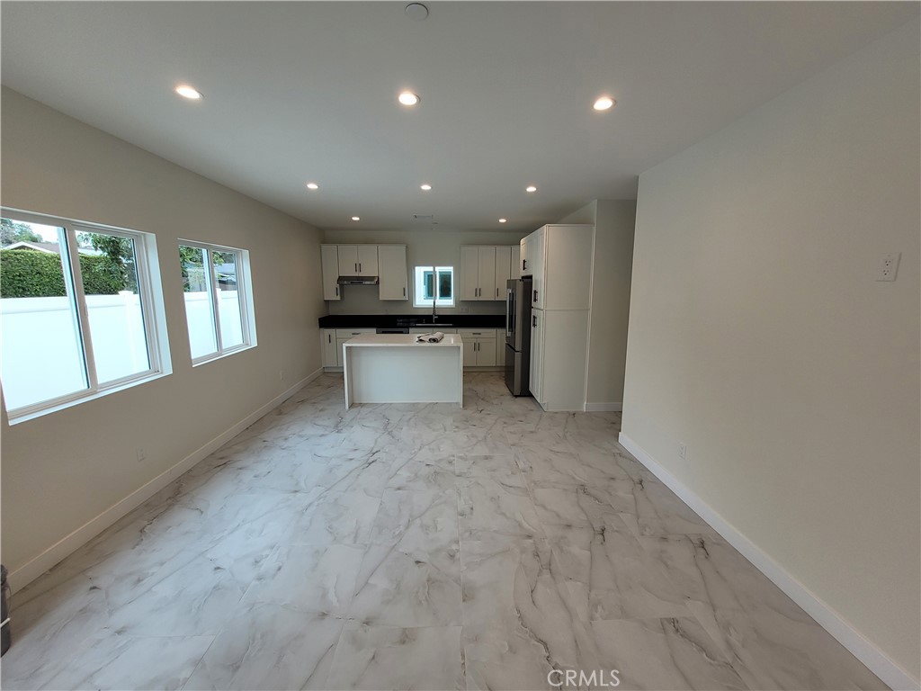 19455 Strathern Street Reseda, CA 91335 - Photo 3 of 11 a view of a kitchen with a sink and dishwasher a refrigerator with wooden floor