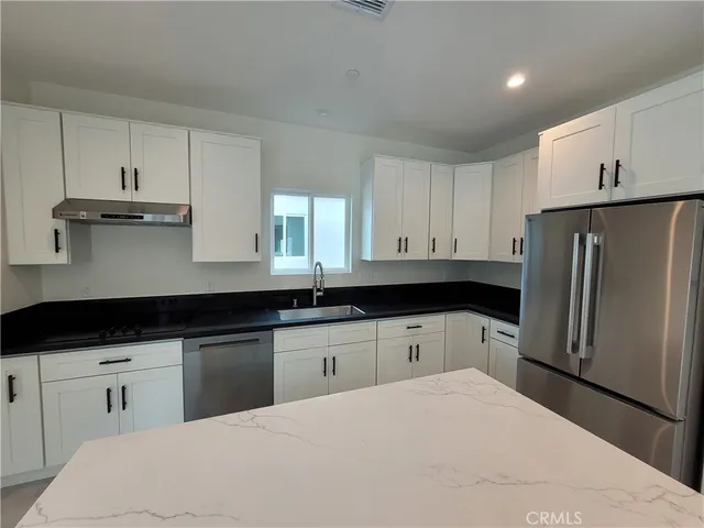 a kitchen with stainless steel appliances a refrigerator sink and cabinets