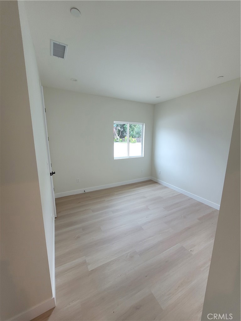 19455 Strathern Street Reseda, CA 91335 - Photo 7 of 11 an empty room with wooden floor and windows