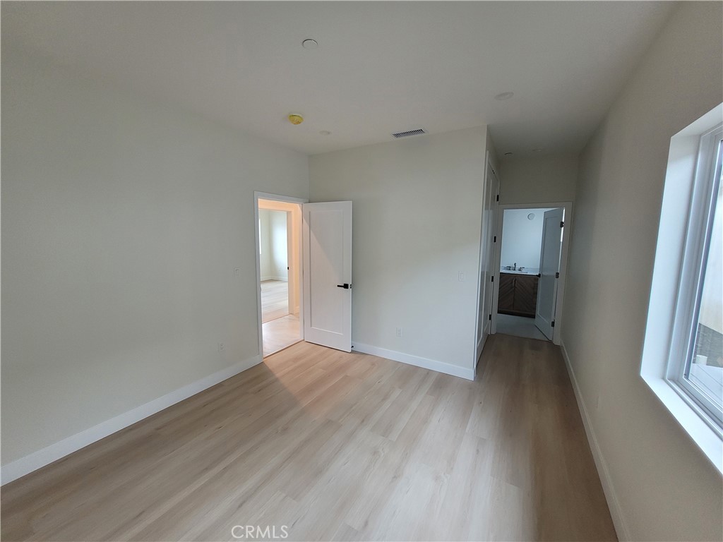 19455 Strathern Street Reseda, CA 91335 - Photo 10 of 11 a view of an empty room with a window and wooden floor