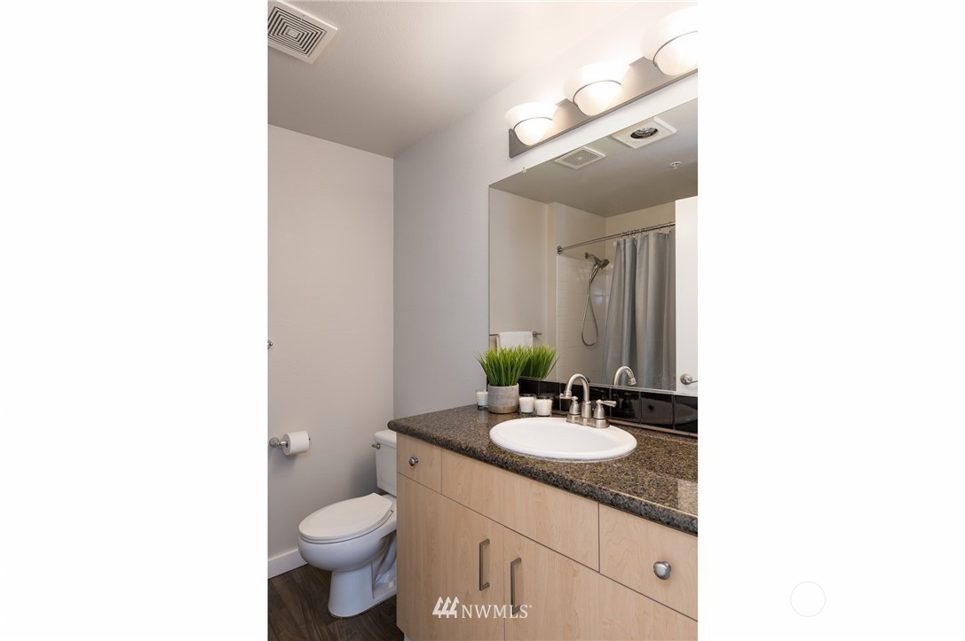 108 5th Avenue South, Unit 402 Seattle, WA 98104 - Photo 11 of 15 a bathroom with a toilet sink and mirror