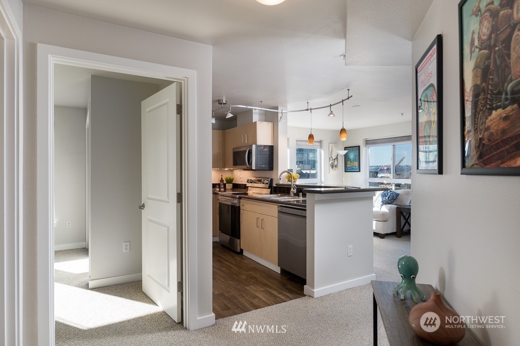 108 5th Avenue South, Unit 402 Seattle, WA 98104 - Photo 5 of 15 a kitchen with stainless steel appliances granite countertop a refrigerator and a sink